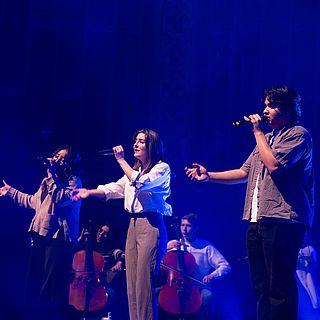 The WWU praise team sings for vespers. They hold their arms out in worship.